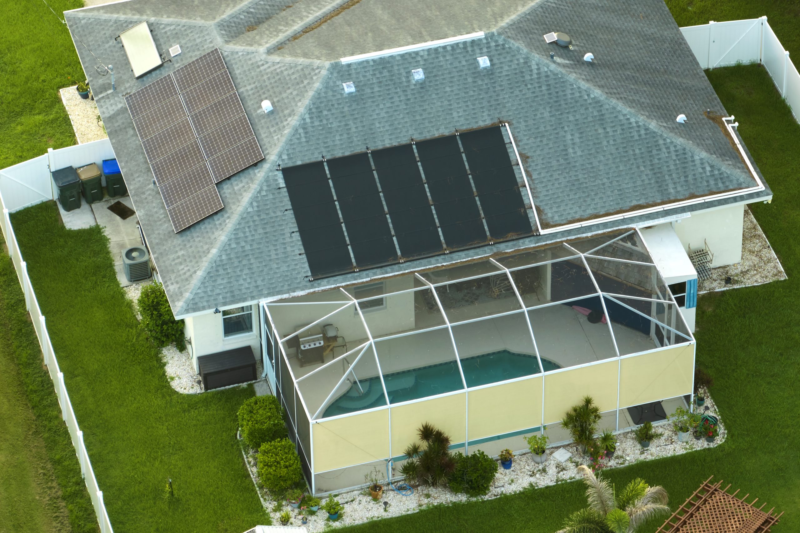 Aerial view of regular american home roof with blue solar photovoltaic panels for producing clean ecological electric energy. Investing in renewable electricity for retirement income aerial-view-of-regular-american-home-roof-with-blu-2026-03-16-04-23-40-utc
