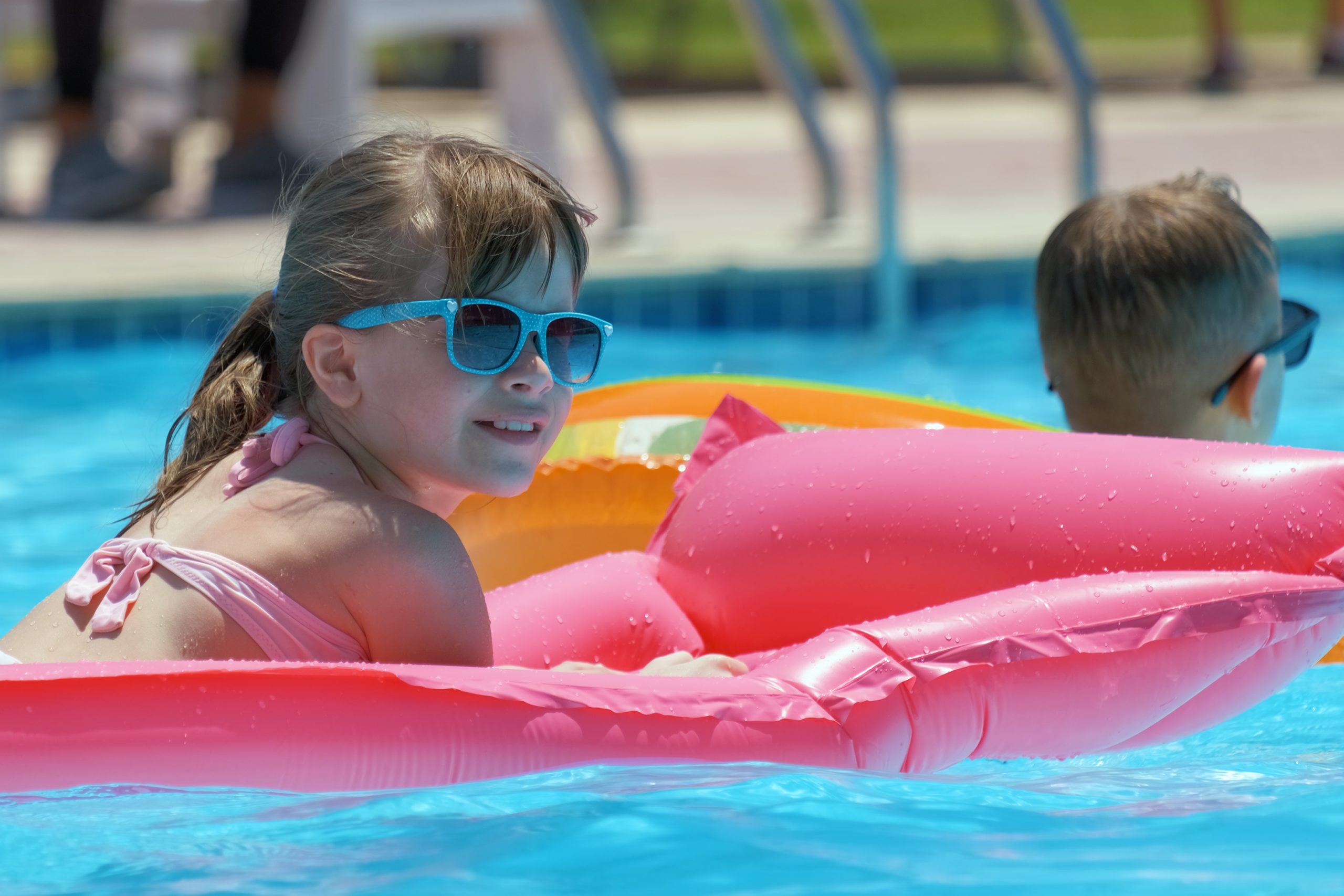 girl-relaxes-on-inflatable-in-pool-bright-day-2026-03-16-00-39-38-utc