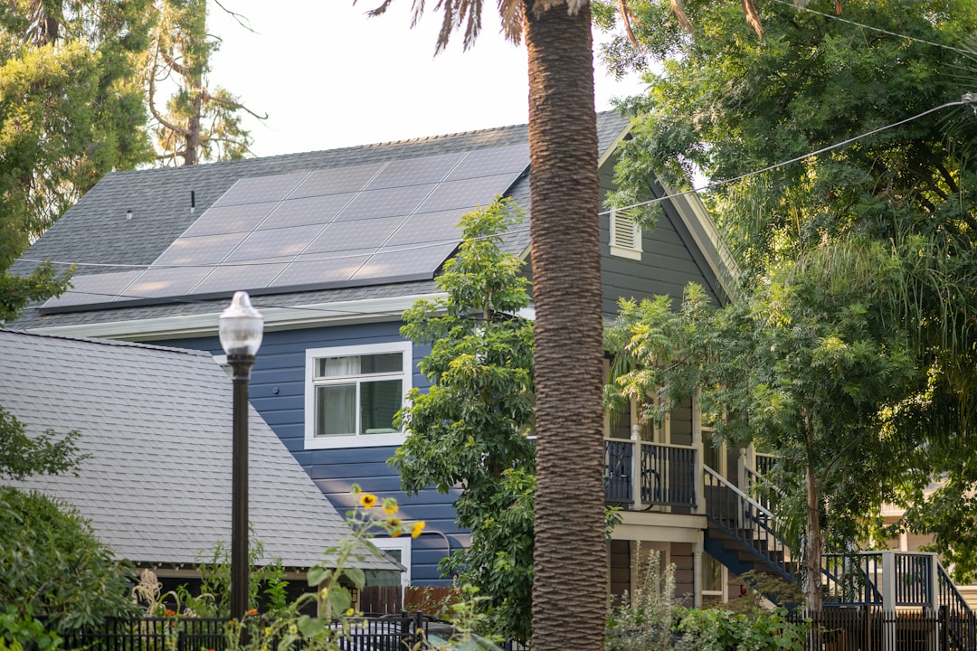 solar inverter replacement cost Sacramento — A blue house surrounded by trees and plants